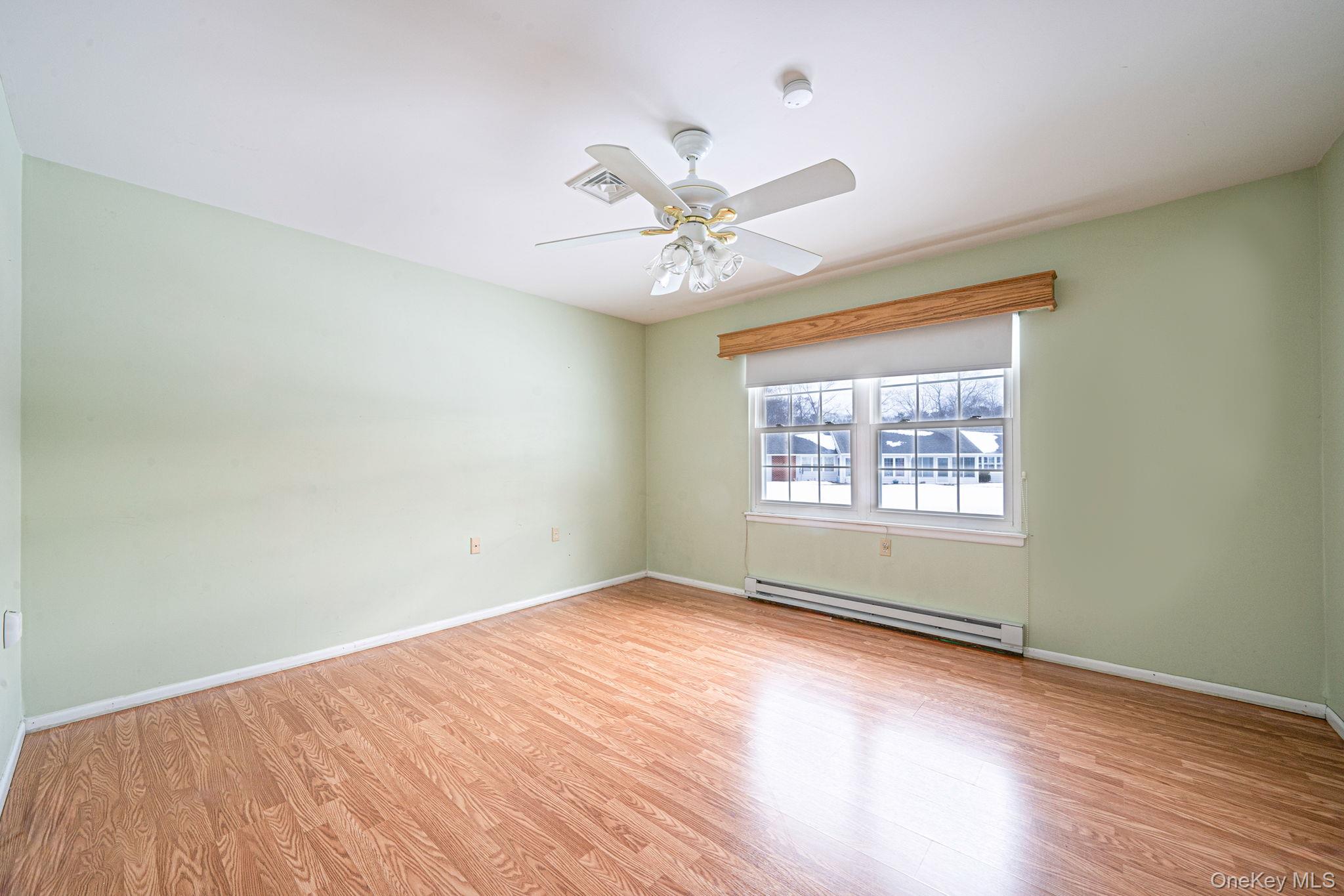 61 Enfield Court, Unit B Ridge, NY 11961 - Photo 22 of 32 wooden floor in an empty room with a window