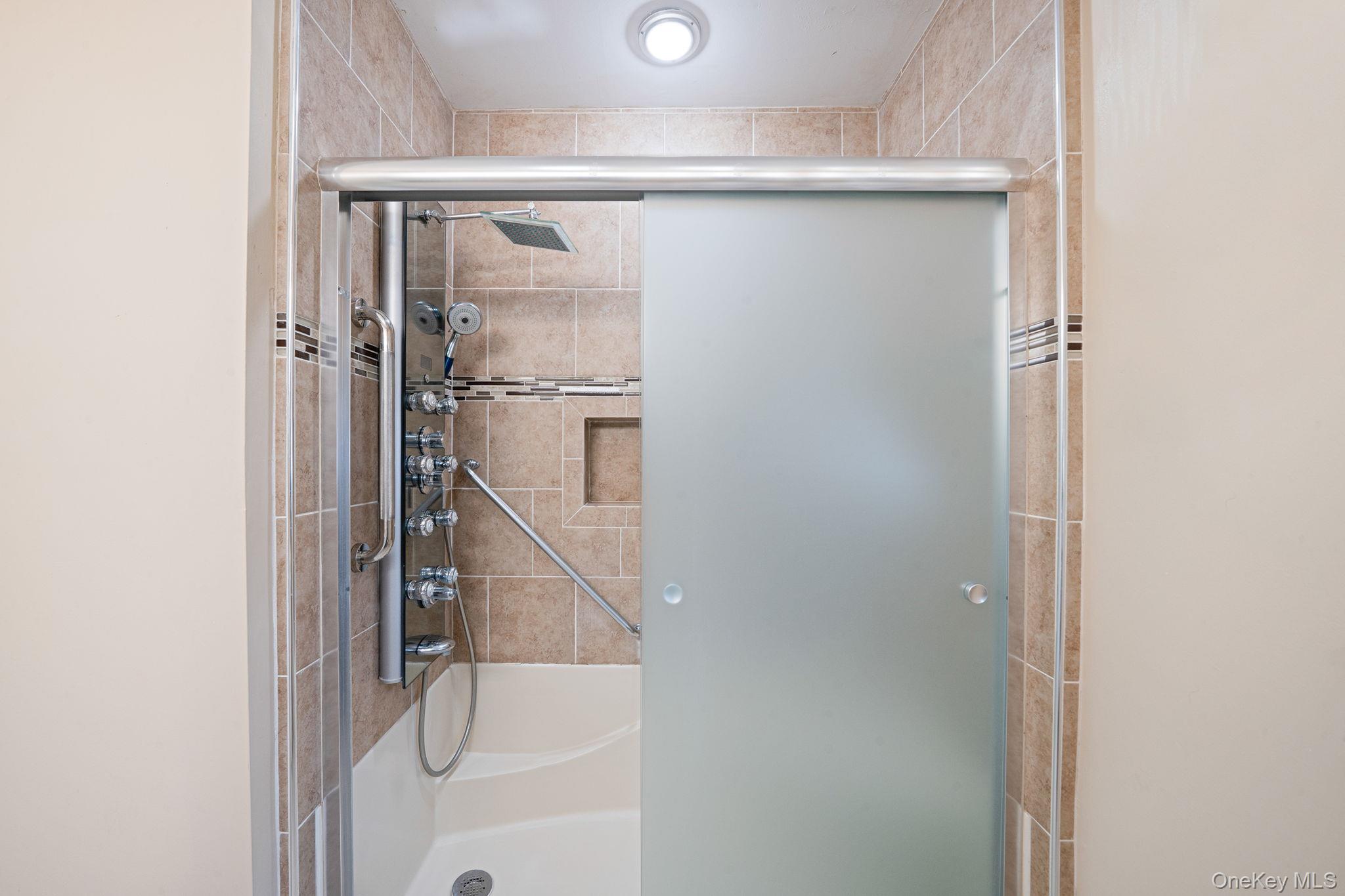 61 Enfield Court, Unit B Ridge, NY 11961 - Photo 29 of 32 a bathroom with a glass shower door