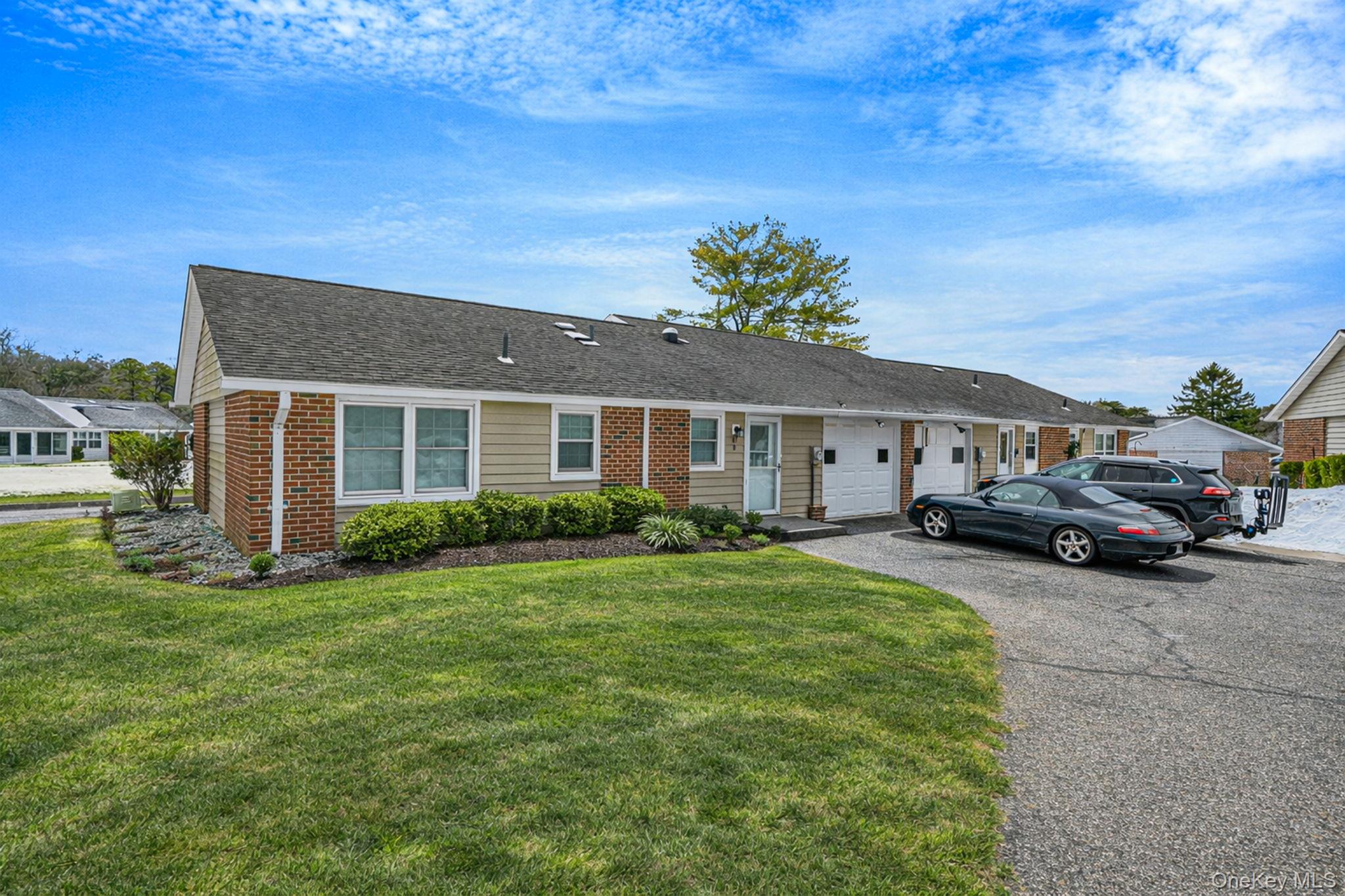 61 Enfield Court, Unit B Ridge, NY 11961 - Photo 3 of 32 a front view of a house with a garden and yard