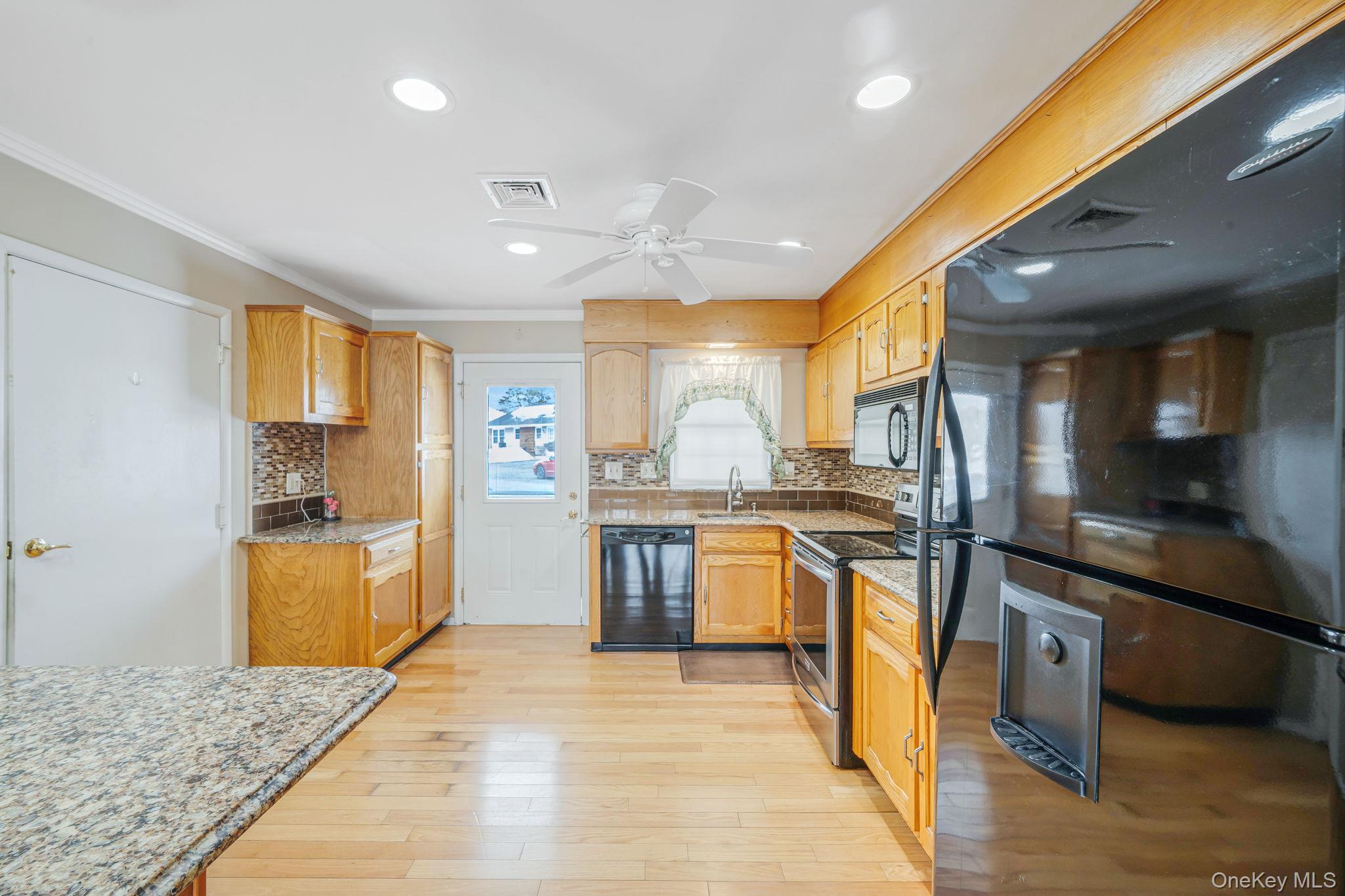 61 Enfield Court, Unit B Ridge, NY 11961 - Photo 10 of 32 a large kitchen with stainless steel appliances granite countertop a sink and cabinets