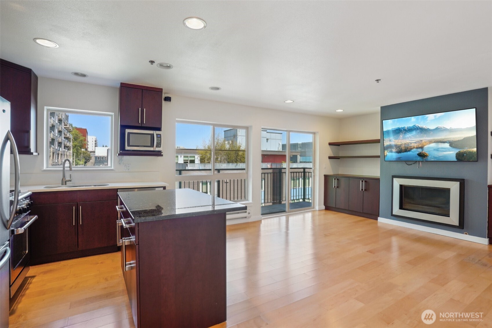 701 Galer Street, Unit 504 Seattle, WA 98109 - Photo 9 of 28 a living room with stainless steel appliances furniture a fireplace a flat screen tv and view kitchen