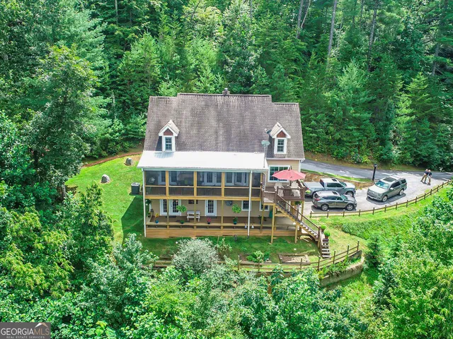 an aerial view of a house with a big yard and large trees
