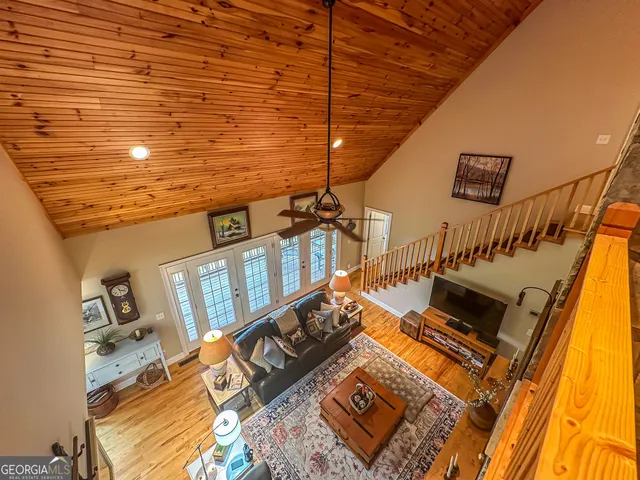 a living room with furniture a bookshelf and a window