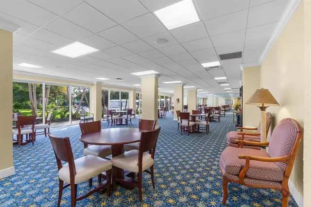 a dining room with furniture a rug and a large window