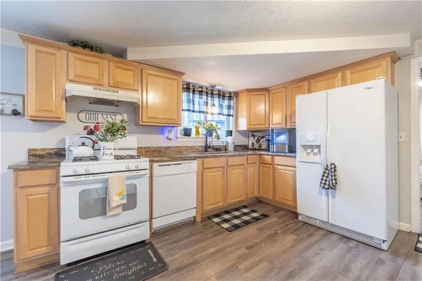 a kitchen with a sink cabinets stainless steel appliances and a window