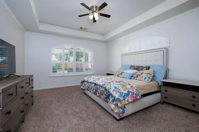 a bedroom with a bed and a ceiling fan