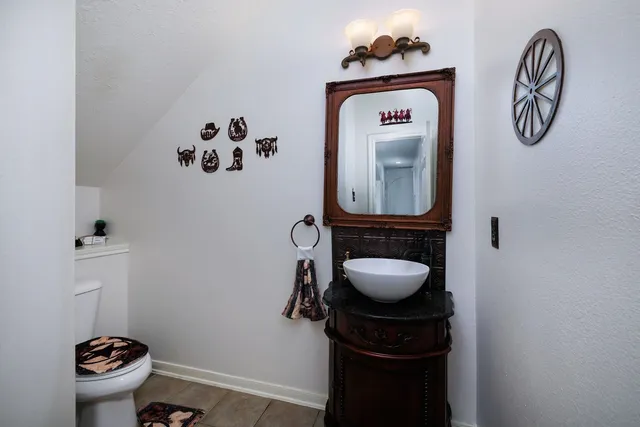 a bathroom with a toilet a sink and mirror