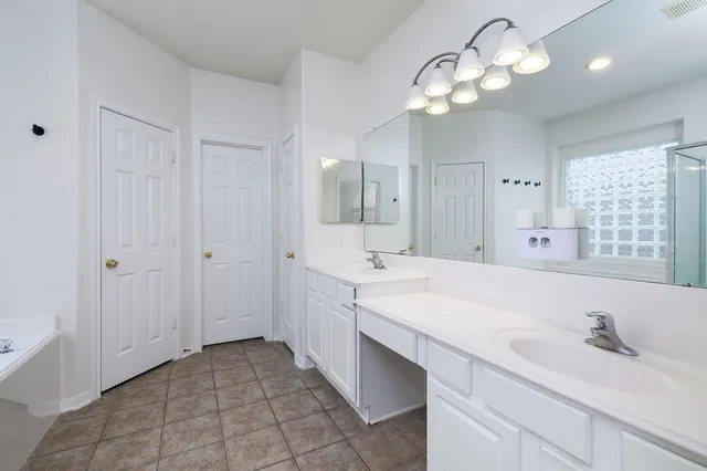 a spacious bathroom with a sink a large mirror and a shower