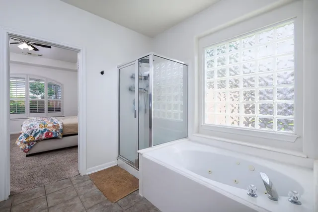a bathroom with a tub mirror and window