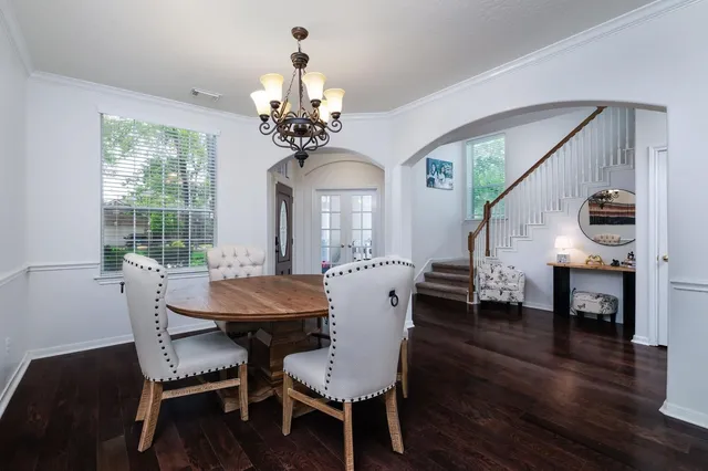 a view of a dining room with furniture a chandelier and wooden floor
