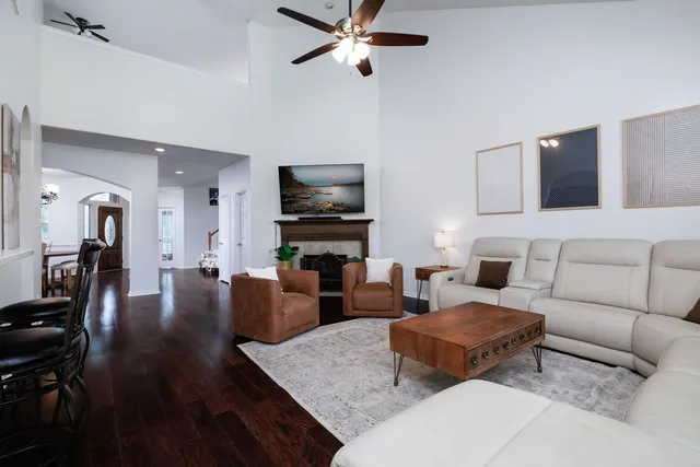 a living room with furniture a flat screen tv and a window