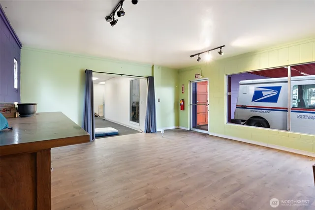 a view of an empty room with a window and a kitchen