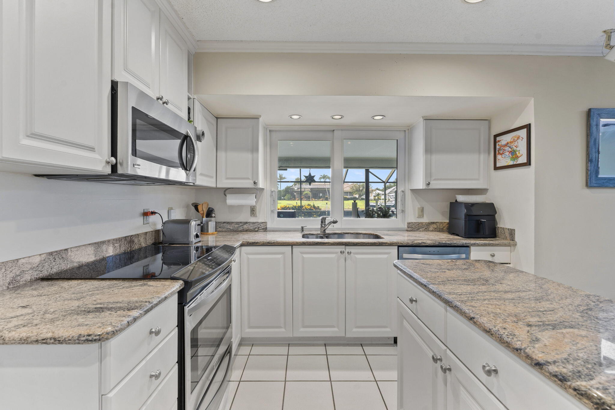 3374 Southeast Fairway East Stuart, FL 34997 - Photo 4 of 65 a kitchen with stainless steel appliances granite countertop a sink stove and cabinets