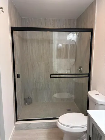 a bathroom with a toilet and a shower