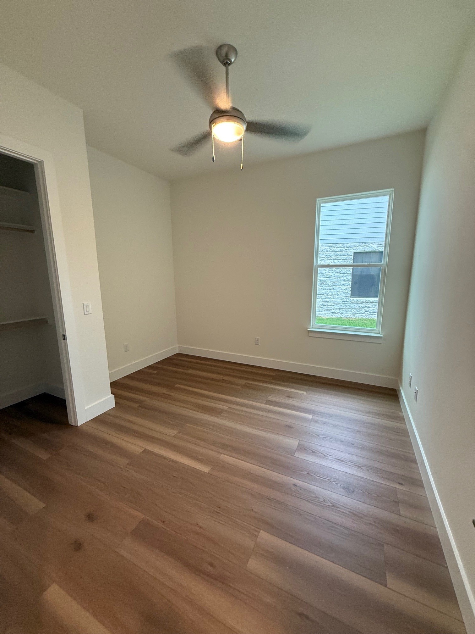 110 Firestone Place Meadowlakes, TX 78654 - Photo 14 of 18 Spacious room featuring wood-finish flooring, white baseboards, and a ceiling fan with integrated lighting
