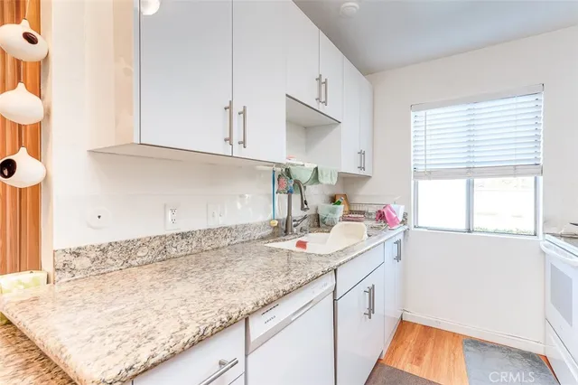 a kitchen with a sink dishwasher and cabinets
