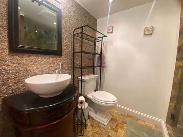 a bathroom with a sink toilet and mirror