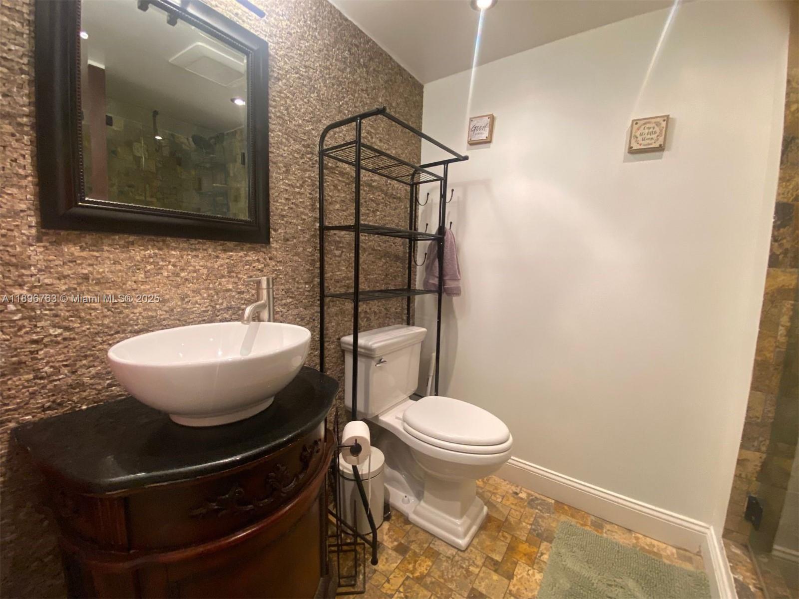753 Michigan Avenue, Unit 2B Miami Beach, FL 33139 - Photo 11 of 22 a bathroom with a sink toilet and mirror
