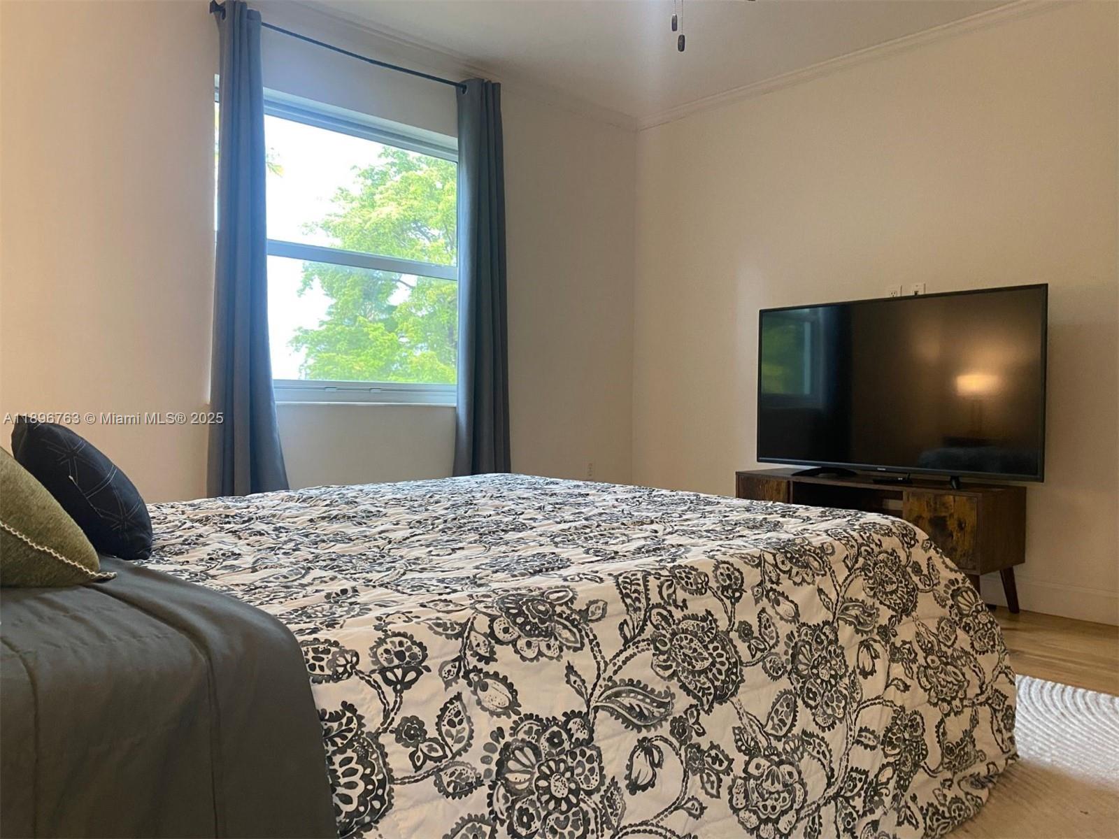 753 Michigan Avenue, Unit 2B Miami Beach, FL 33139 - Photo 18 of 22 a bedroom with a bed and television