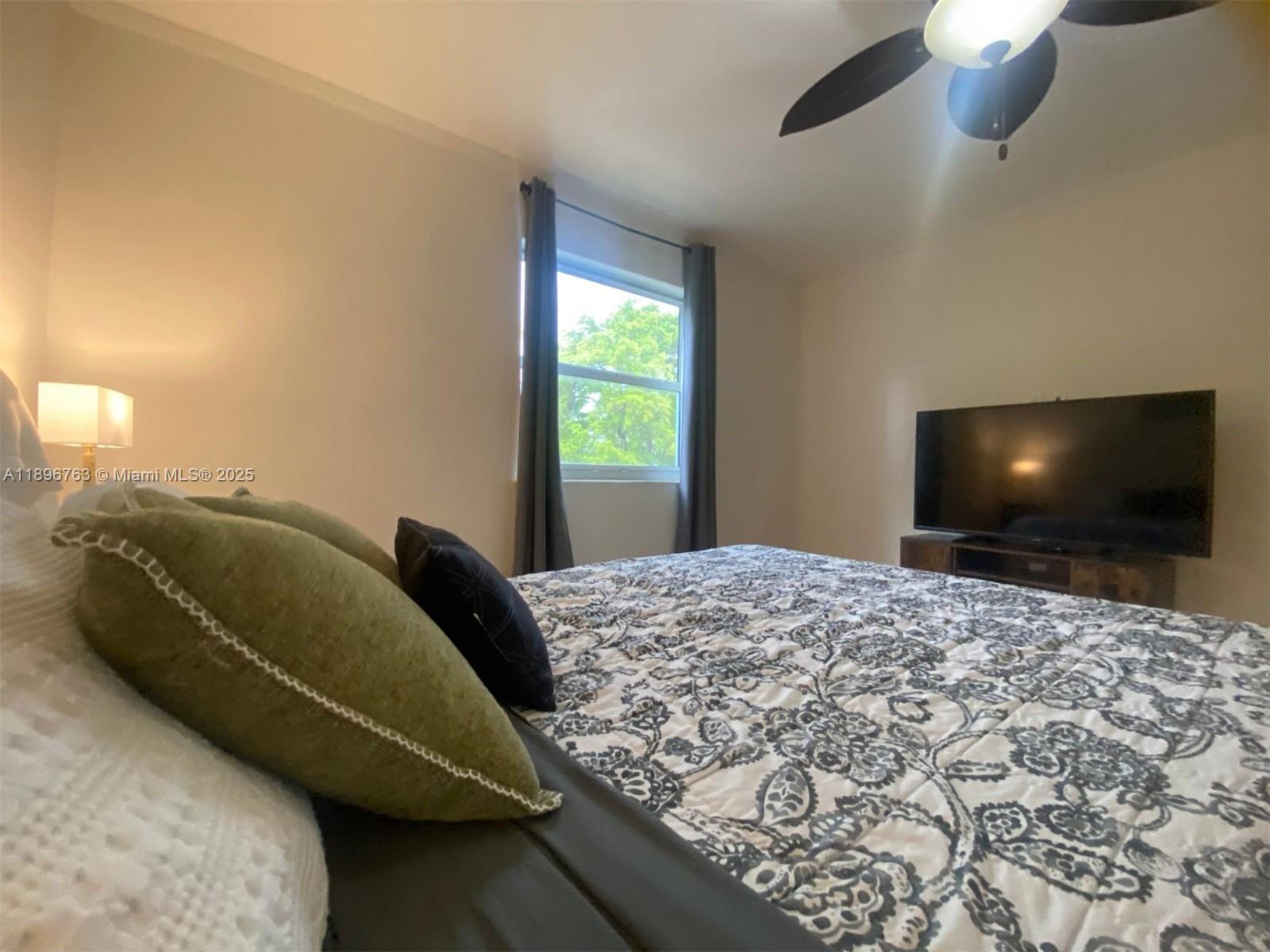 753 Michigan Avenue, Unit 2B Miami Beach, FL 33139 - Photo 20 of 22 a bedroom with a bed and a flat screen tv