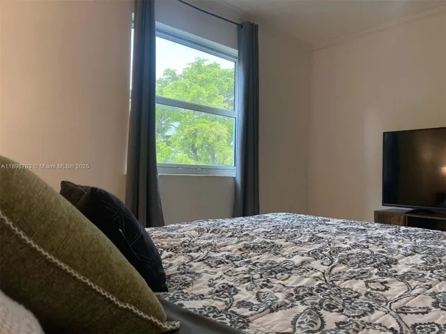 a bedroom with a bed and a flat screen tv