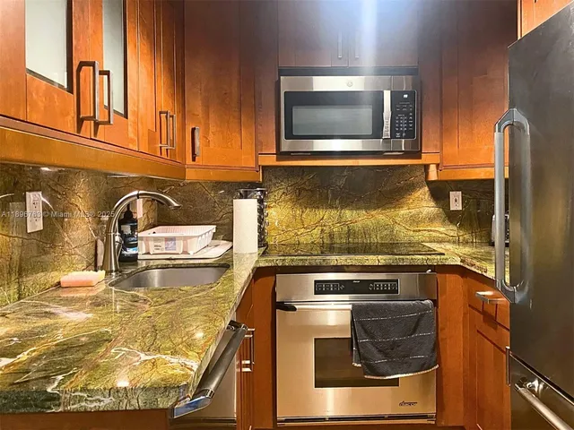 a kitchen with granite countertop a stove and a sink