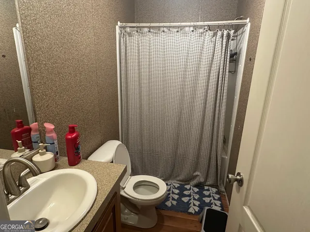 a bathroom with a sink a toilet and a mirror