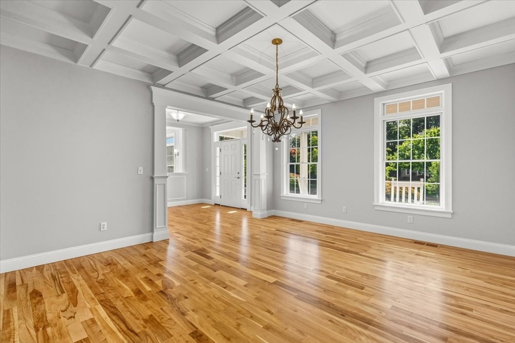 118 Bates Way Hanover, MA 02339 - Photo 10 of 42 a view of an empty room with wooden floor and a chandelier