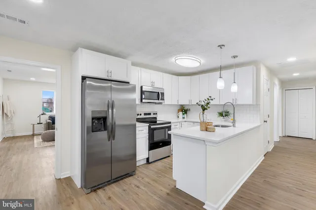 a kitchen with stainless steel appliances a refrigerator sink and microwave