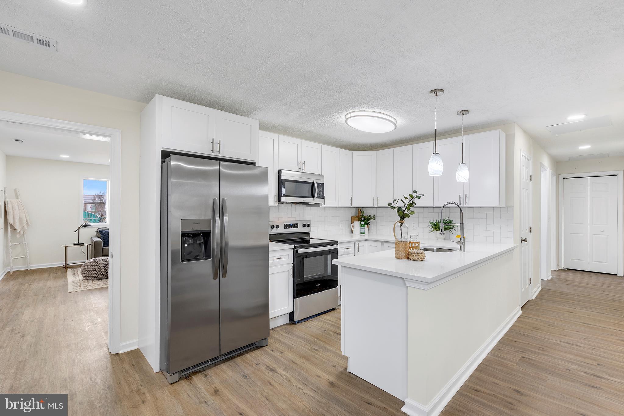 a kitchen with stainless steel appliances a refrigerator sink and microwave