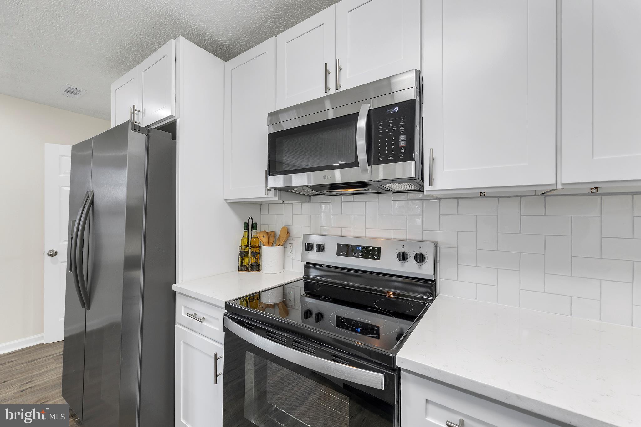 723 Cotter Road Glen Burnie, MD 21060 - Photo 4 of 31 a kitchen with stainless steel appliances a stove a microwave and a refrigerator