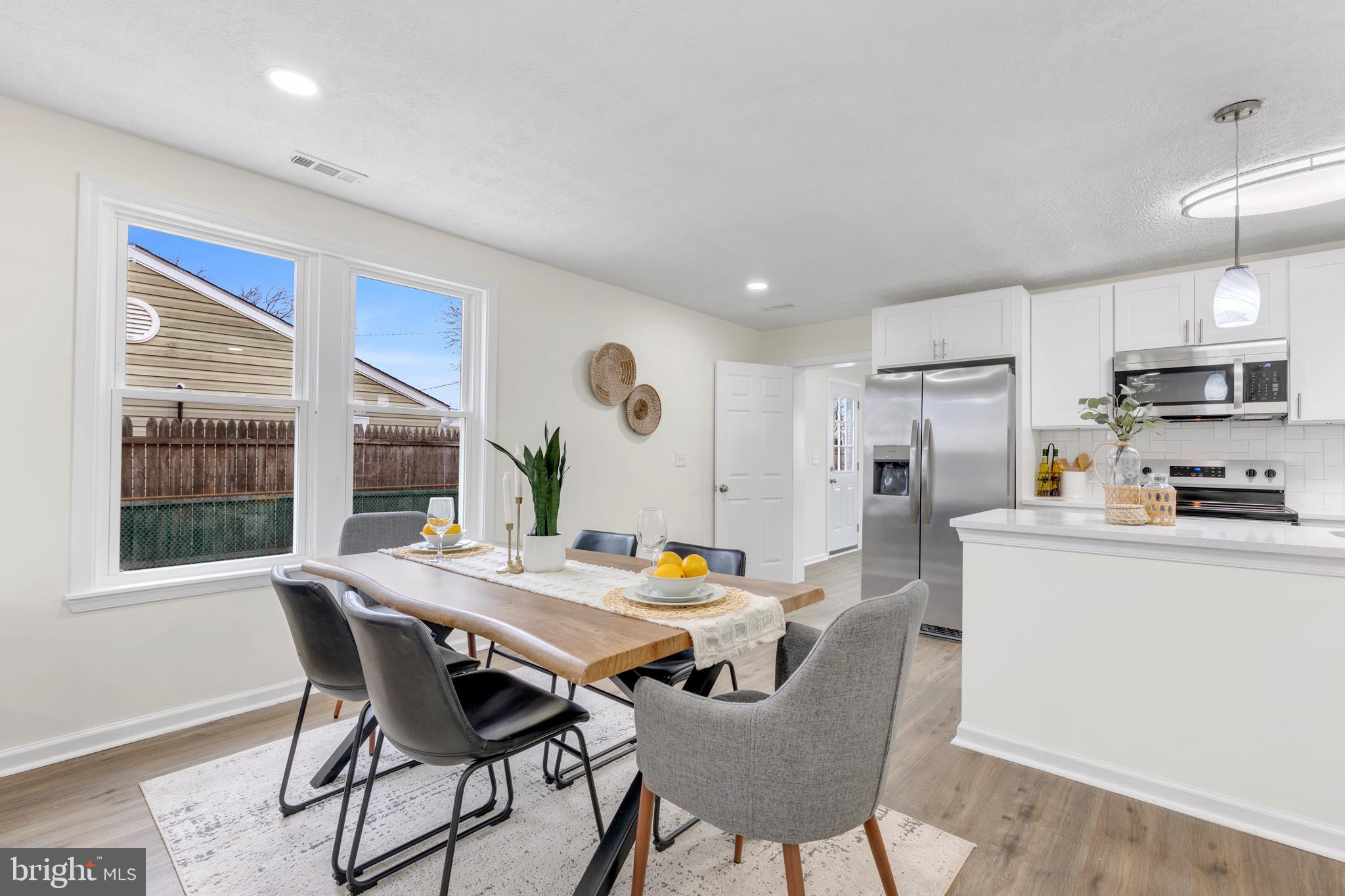 723 Cotter Road Glen Burnie, MD 21060 - Photo 9 of 31 a kitchen with stainless steel appliances a dining table chairs and a refrigerator