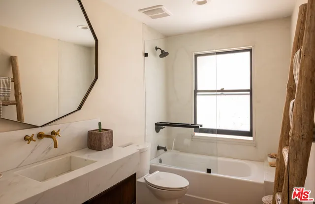 a bathroom with a tub sink and mirror