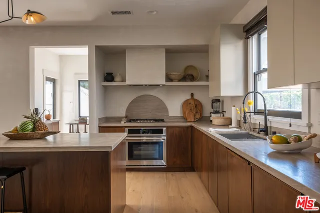 a kitchen with stainless steel appliances granite countertop a sink stove and cabinets