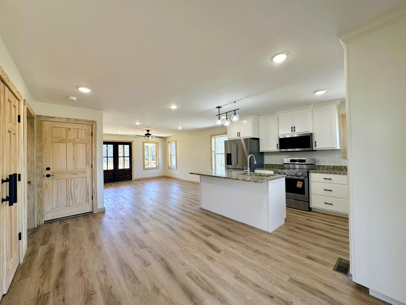 3840 Federal Road Counce, TN 38326 - Photo 39 of 40 Kitchen featuring open floor plan, decorative light fixtures, stainless steel appliances, a kitchen island with sink, and white cabinetry