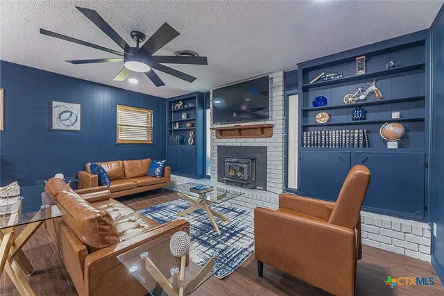 a living room with furniture a bookshelf and a wooden floor