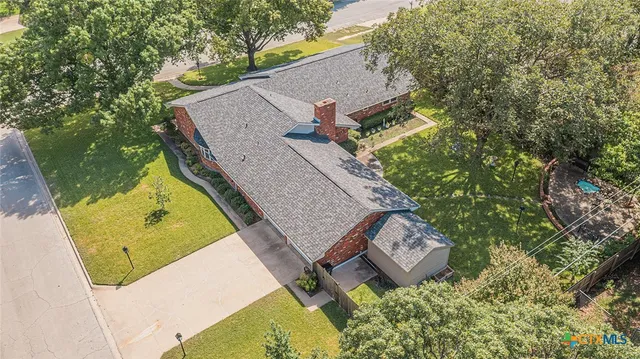 an aerial view of a house with garden space and street view