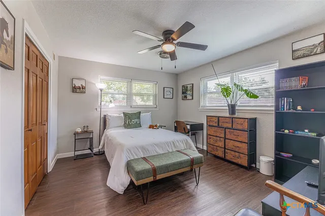 a bedroom with a bed and a window with wooden floor