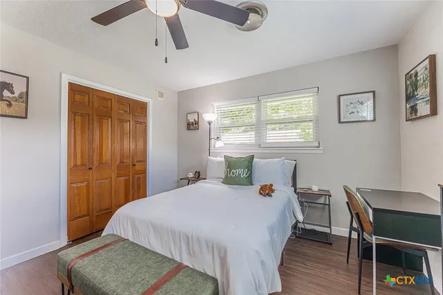 a bedroom with a bed a table and chair