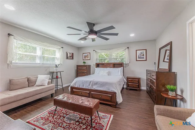 a spacious bedroom with a bed a couch and a window
