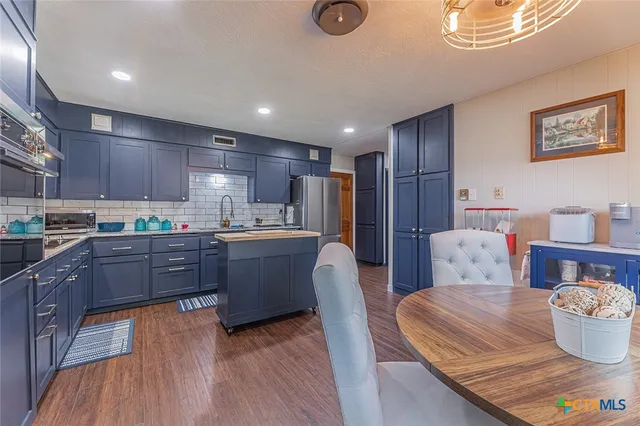 a kitchen with a wooden table and chairs