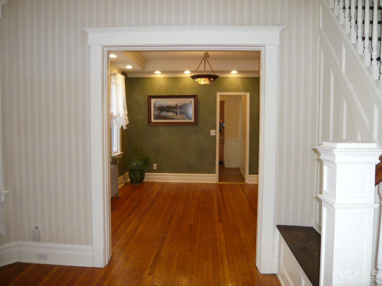 232 Rector Street Perth Amboy, NJ 08861 - Photo 12 of 31 a view of a hallway with wooden floor and a refrigerator