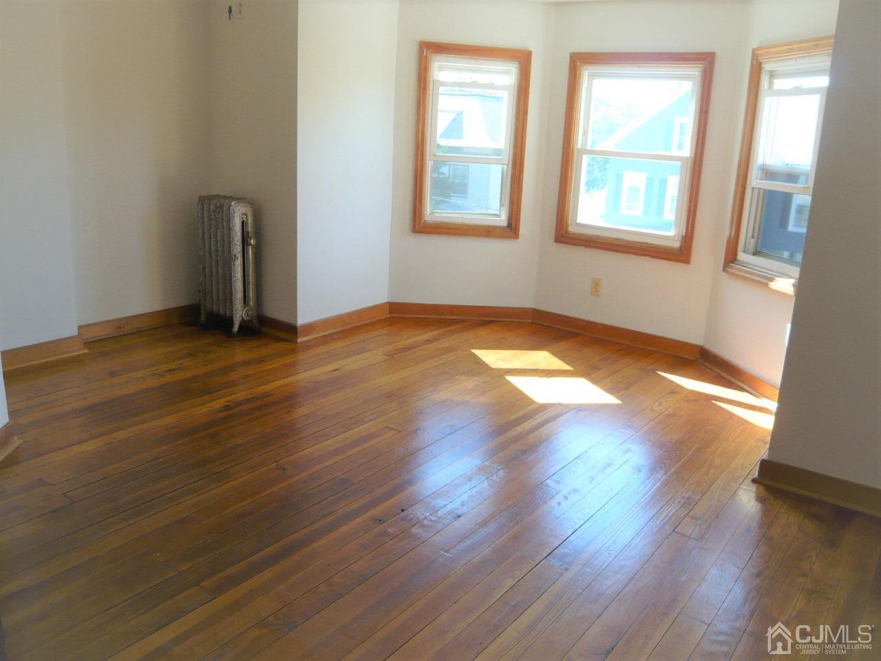 232 Rector Street Perth Amboy, NJ 08861 - Photo 24 of 31 an empty room with wooden floor and windows