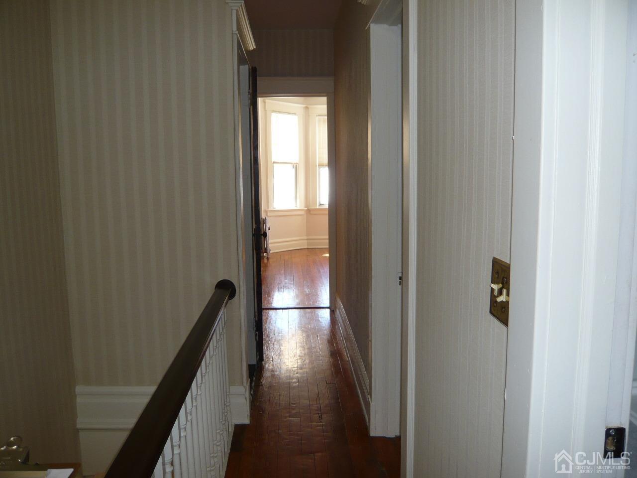 232 Rector Street Perth Amboy, NJ 08861 - Photo 29 of 31 a view of a hallway with wooden floor and stairs