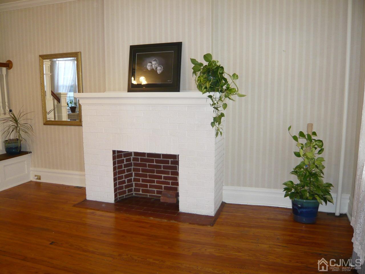 232 Rector Street Perth Amboy, NJ 08861 - Photo 6 of 31 an empty room with wooden floor and a potted plant