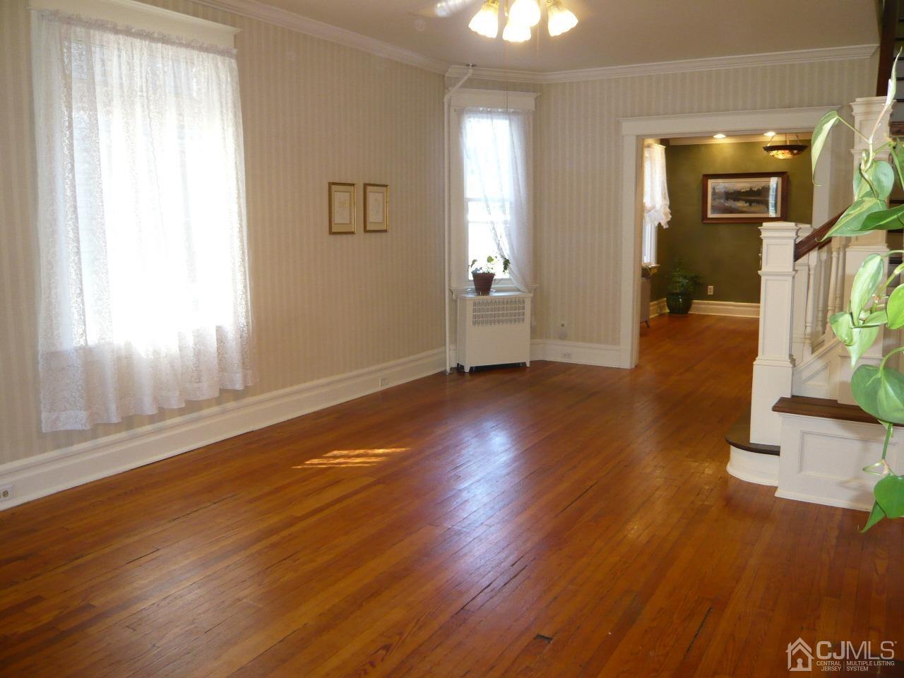 232 Rector Street Perth Amboy, NJ 08861 - Photo 9 of 31 an empty room with wooden floor and windows