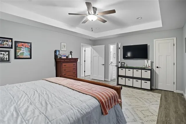 a bedroom with a bed and a flat tv screen on dresser