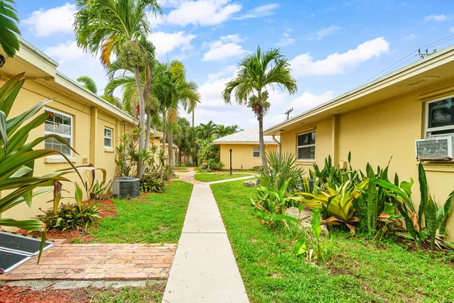 a view of a house with backyard and a tree