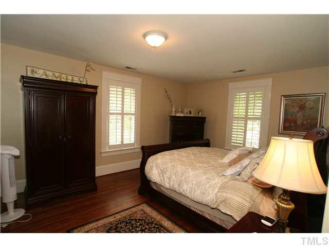 2112 Fairview Road Raleigh, NC 27608 - Photo 15 of 25 a bedroom with a bed and wooden floor