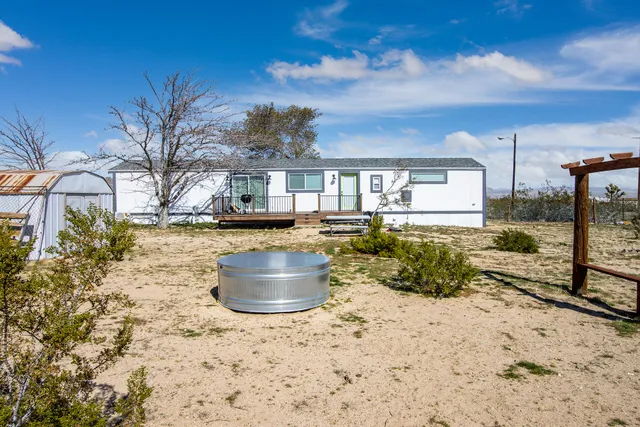 a view of a dry yard with wooden fence